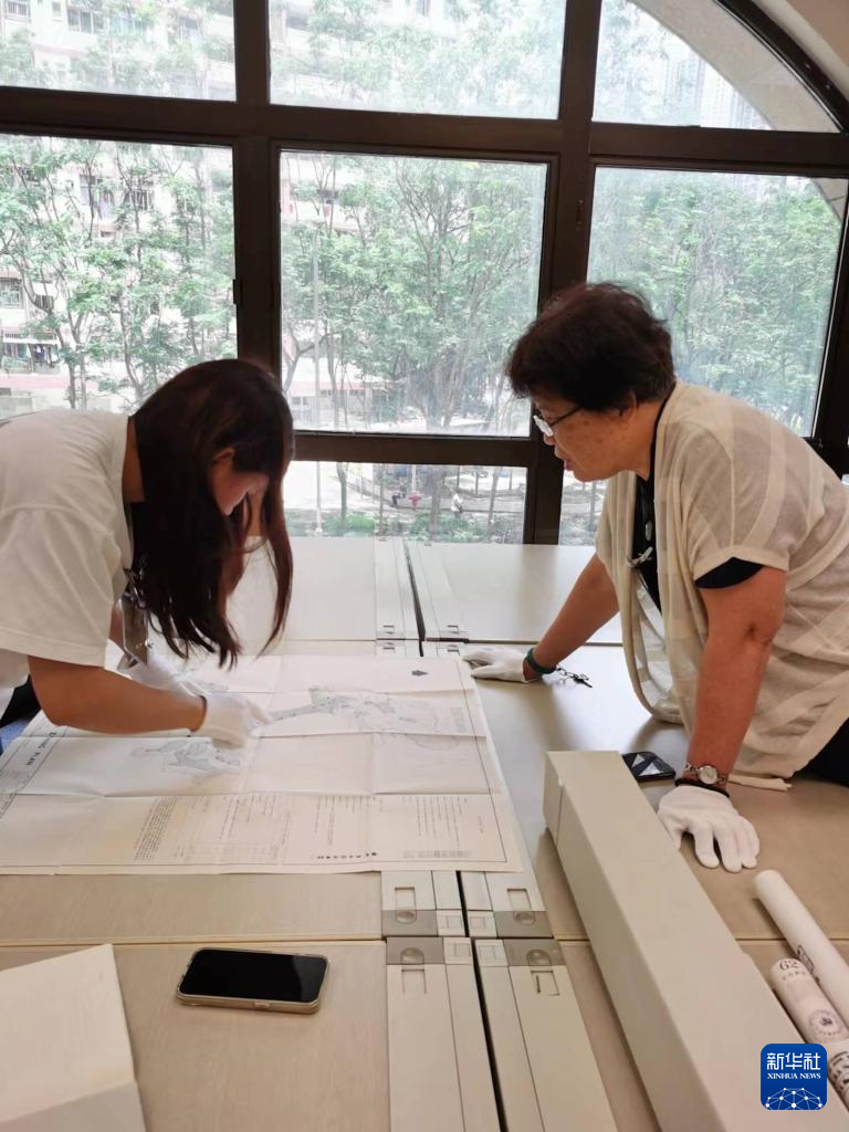 6月12日，东江纵队老战士刘克强的外孙女黎诗雅（左）与东江纵队老战士后人、香港抗战史研究者王玉珍在香港历史档案大楼查阅史料。新华社发