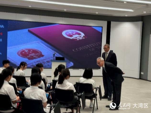 岑浩辉（右一）与正在倾听普法讲座的中学生们交流。人民网记者 富子梅摄