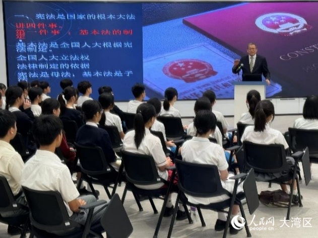 澳门大学法学院教授骆伟建在青少年普法讲座上为中学生讲解宪法和澳门基本法。人民网记者 富子梅摄