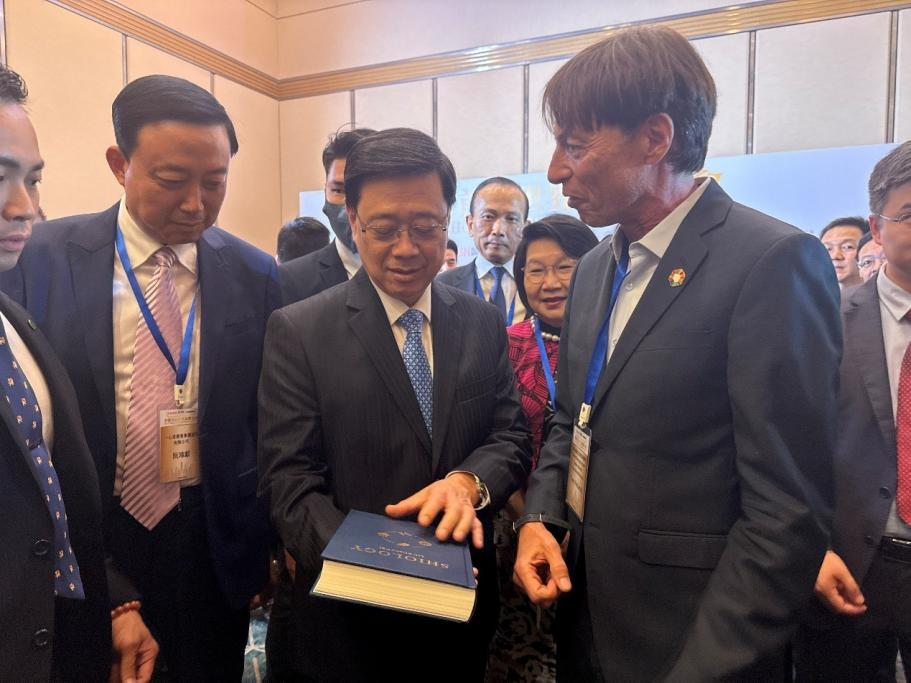 图1.世界食事论坛国际战略高级顾问、联合国FAO/WHO食品法典委员会原秘书长Tom Dietmar Heilandt向李家超赠送《Shiology》。主办方供图