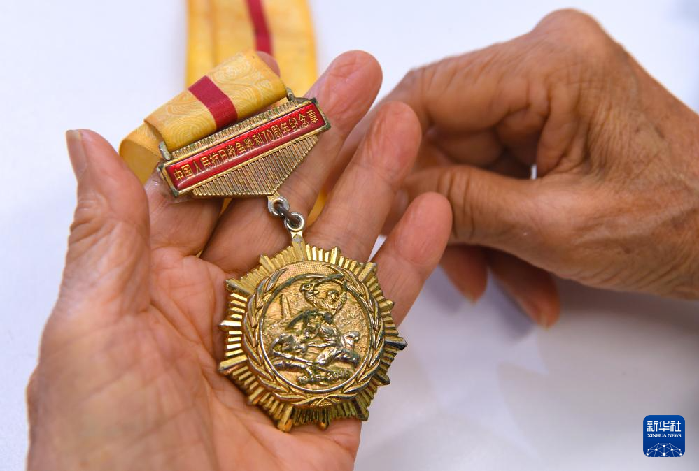 6月24日，在香港屯门欣田邨服务处，90岁的抗日老战士林珍展示她荣获的纪念章。新华社记者 陈铎 摄