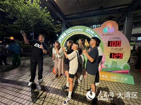 图为澳门居民与全运会倒计时牌合影留念。人民网记者 富子梅摄
