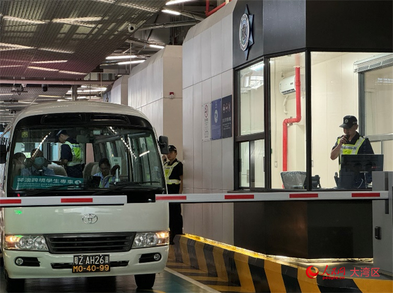 图为第一辆跨境学生专车接受澳门海关登车查验、学生免下车通关服务新举措。人民网记者 富子梅摄