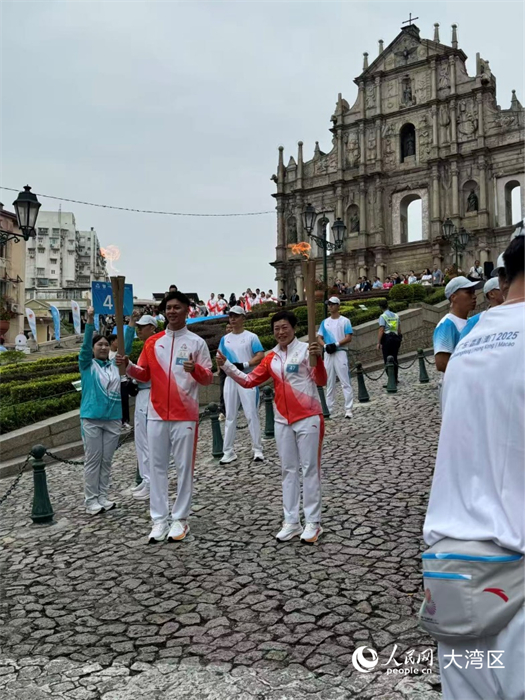 图为第47棒和48棒火炬手在大三巴牌坊前交接。人民网记者 富子梅摄