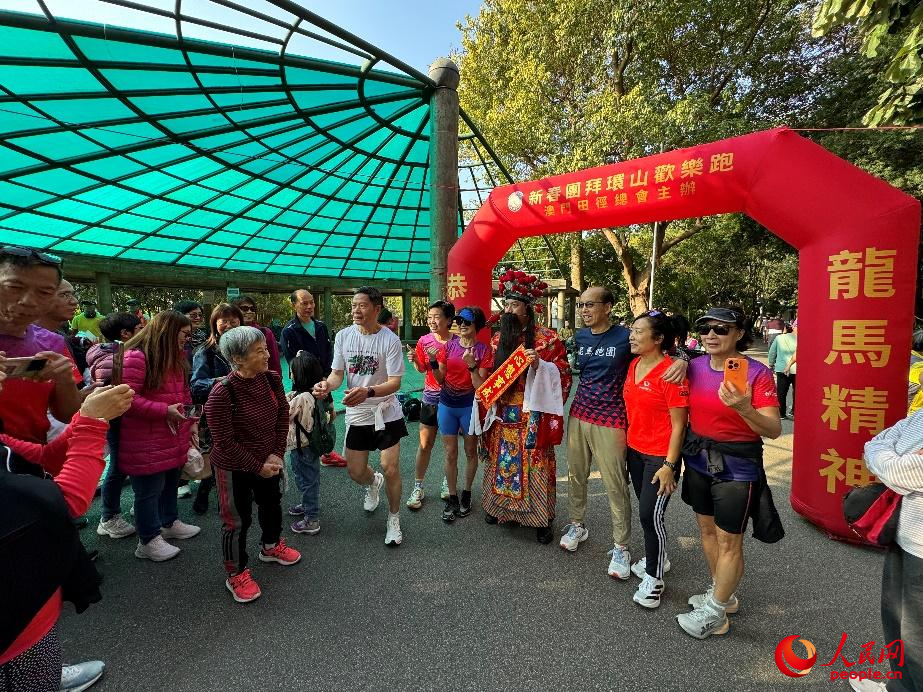 图为春节登山欢乐跑的澳门居民巧遇“财神”。人民网记者 富子梅摄