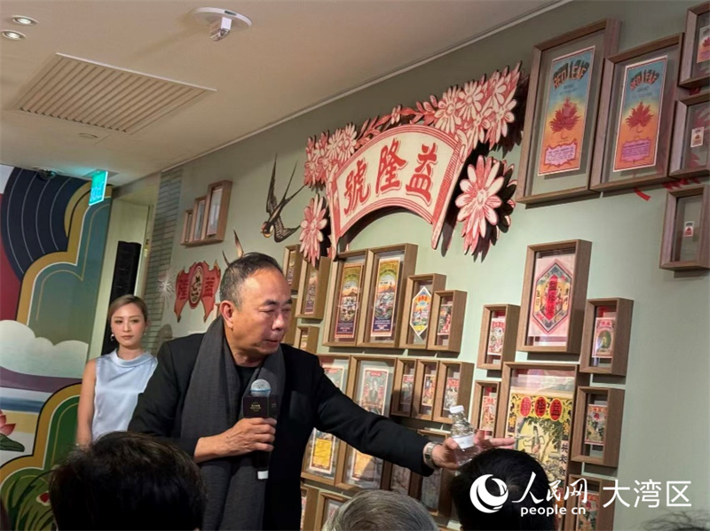 策展人吴卫鸣教授为观众讲解包装招纸展品。人民网富子梅摄