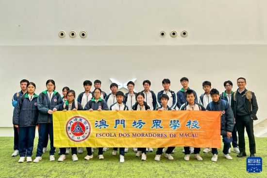 澳门坊众学校学生在小鹏汽车广州总部合影留念（3月21日摄）。新华社记者 郭雨祺 摄