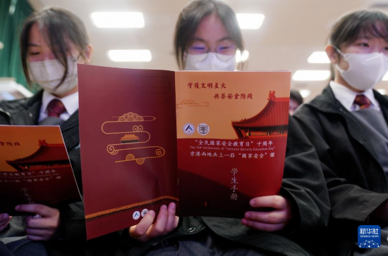   4月9日，在香港培侨中学，学生在“京港两地共上一堂国安课”活动上阅读学生手册。新华社发（王申摄）