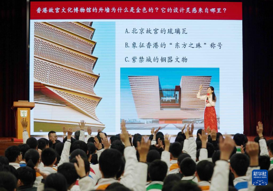   4月9日，在香港培侨中学，北京人大附中分校教师高维阳在活动上提出活跃气氛的问题，学生踊跃举手回答。新华社发（王申摄）