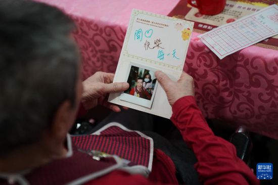 5月24日,在香港松悦园耆和护养院,老人们在餐后得到暖心拍立得照片和祝福卡片。新华社发(王申 摄)