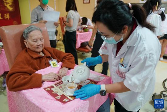 5月24日,在香港松悦园耆和护养院,身穿白衫的伙计在“茶楼”售卖茶点,端茶倒水。新华社发(王申 摄)