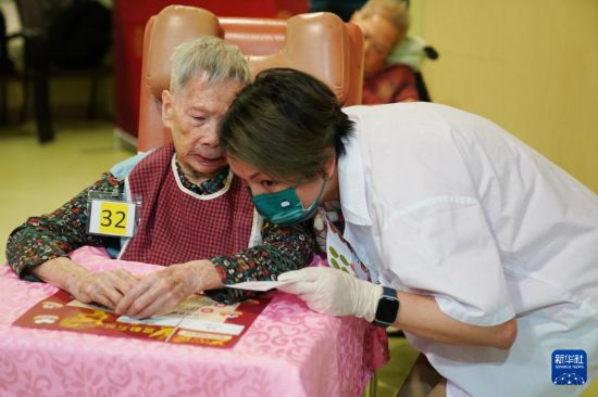 5月24日,在香港松悦园耆和护养院,扮演成茶楼伙计的义工高微薇(右)在倾听老人点餐。新华社发(王申 摄)