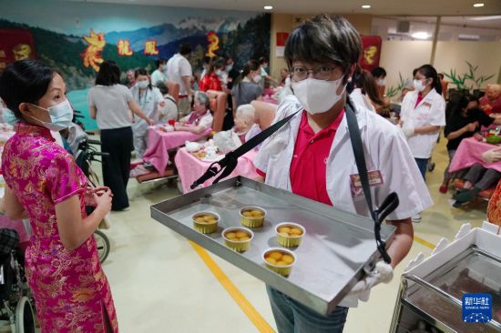 5月24日,在香港松悦园耆和护养院,身穿白衫的伙计在“茶楼”售卖茶点,端茶倒水。新华社发(王申 摄)