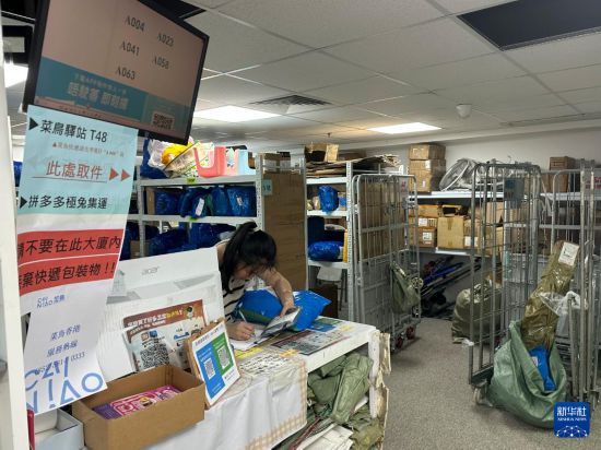 6月16日,工作人员在香港一快递包裹自提点忙碌。新华社发(郭辛摄)