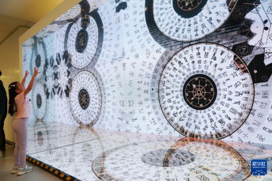 7月11日，在香港中央图书馆，小女孩被甲骨文的视频动画吸引。新华社发（王申 摄）