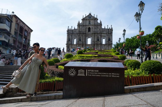 2025年7月9日，游客在澳门大三巴牌坊前游览。新华社发（张金加 摄）