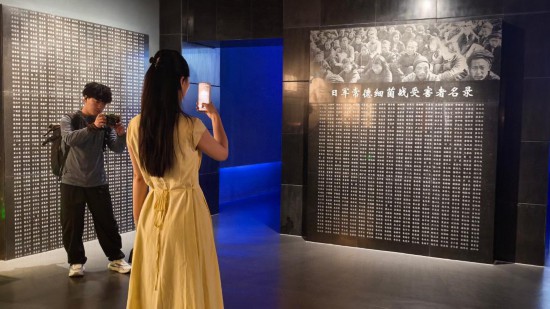 8月1日，采访团成员在常德博物馆拍摄日军常德细菌战受害者名录。新华社记者 马欣然 摄