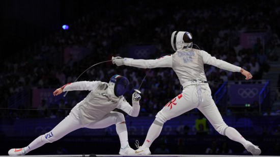 2024年7月29日，中国香港选手张家朗（右）在巴黎奥运会击剑项目男子个人花剑决赛中战胜意大利选手菲利波·马基，夺得冠军。新华社记者 费茂华 摄
