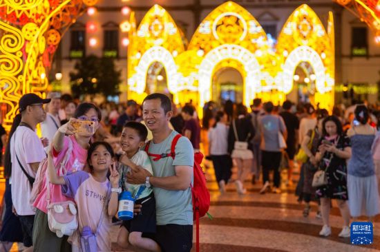 10月6日，游客在澳门议事亭前地游览、拍照。新华社发（张金加摄）