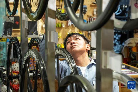 10月13日，在香港荃湾环贸广场，黄金宝在他经营的单车店内整理商品。新华社记者 朱炜 摄