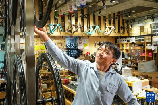 10月13日，在香港荃湾环贸广场，黄金宝在他经营的单车店内整理商品。新华社记者 朱炜 摄