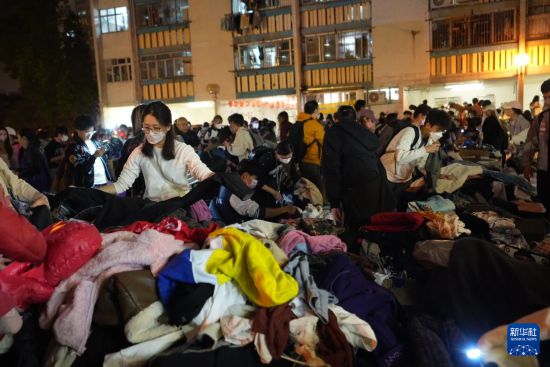 11月27日，义工在宏福苑附近向受火灾影响的市民派发物资。新华社发（吕小炜摄）