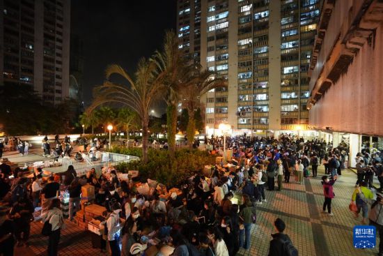 11月27日，义工在宏福苑附近向受火灾影响的市民派发物资。新华社发（吕小炜摄）