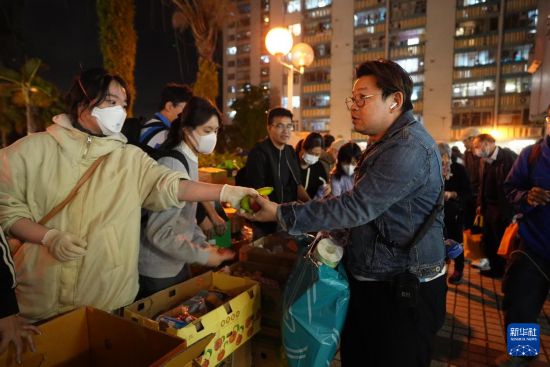  11月27日，义工在宏福苑附近向受火灾影响的市民派发物资。新华社发（吕小炜摄）