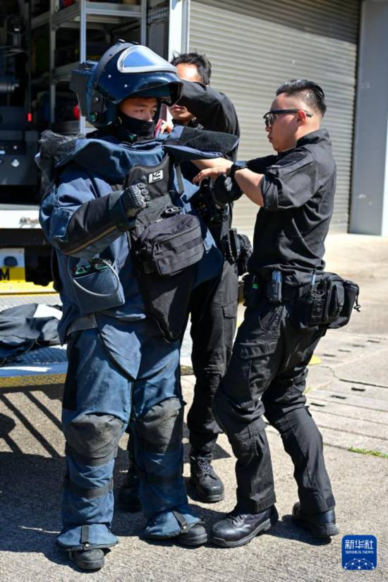 香港警务处爆炸品处理课队员协助同事穿防爆服（2025年11月6日摄）。新华社记者 朱炜 摄
