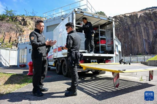 香港警务处爆炸品处理课高级炸弹处理主任李展超（左）与队员交谈（2025年11月6日摄）。新华社记者 朱炜 摄