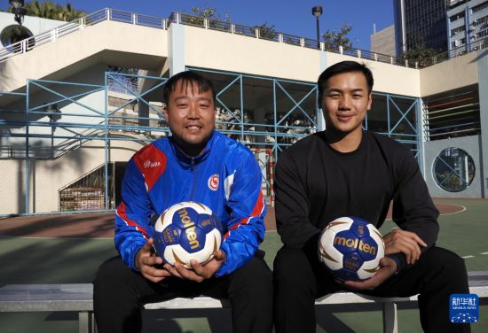 在香港新蒲岗彩虹道150号的露天游乐场，香港男子手球队主教练许文邦（左）和队长谢永辉一起接受记者拍照（2025年12月17日摄）。新华社发（王申摄）