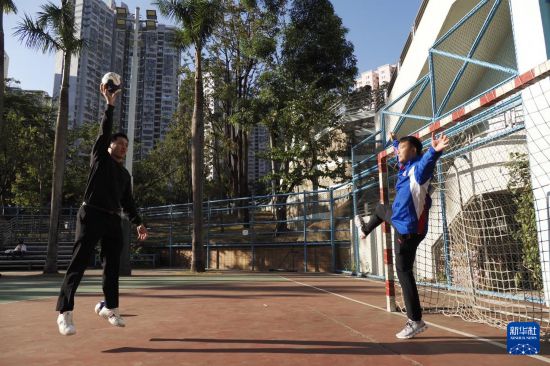 　在香港新蒲岗彩虹道150号的露天游乐场，香港男子手球队主教练许文邦和队长谢永辉（左）在打手球（2025年12月17日摄）。新华社发（王申摄）