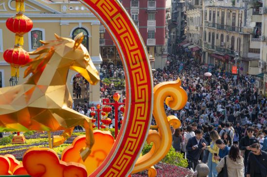 2月20日，游客在澳门大三巴牌坊前游览。新华社发（张金加 摄）