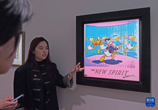 3月24日，工作人员在佳士得香港2026春季拍卖预展上讲解安迪·沃荷的作品《新精神（唐老鸭）》。新华社记者陈铎摄
