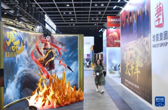 3月17日，在香港会展中心，一名参观者从香港国际影视展海报前走过。新华社记者 陈铎 摄