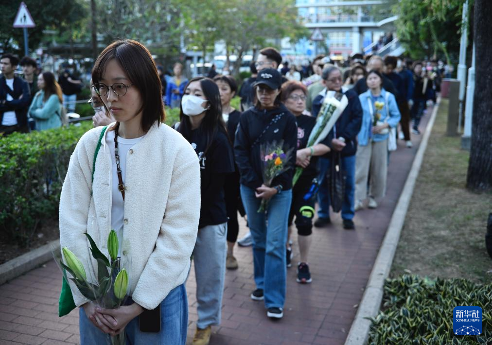 11月29日，在香港大埔宏福苑附近公园，人们排起长队等待献花。新华社发（王申摄）