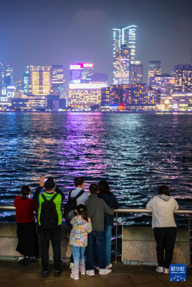 2月20日，游客在香港湾仔海滨观看夜景。新华社记者 朱炜 摄
