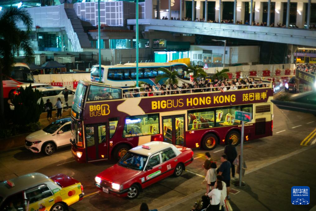 2月20日，在香港中环码头外，游客乘坐“落日飞车”游览。新华社记者 朱炜 摄
